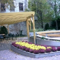 Blick auf die Pergola und ein Blumenbeet im Herbst